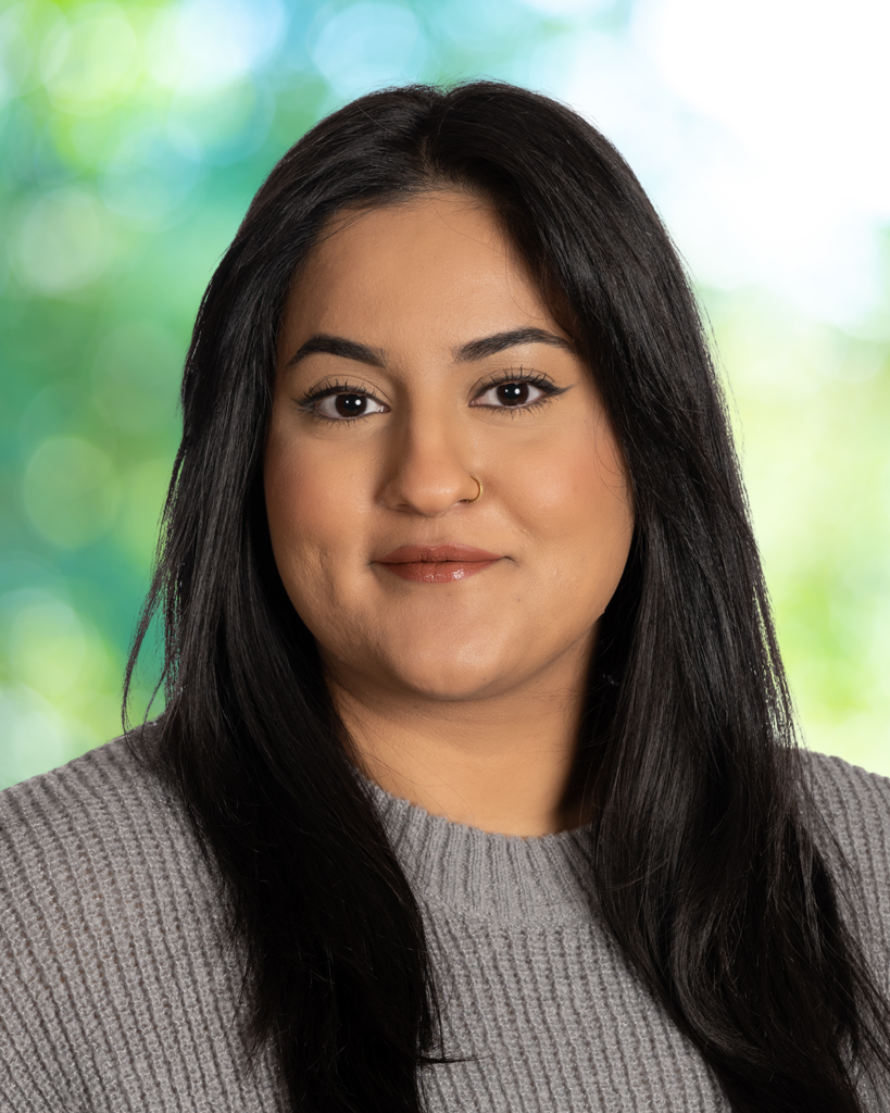 有着深色中等长度头发的南亚女性，面带微笑。