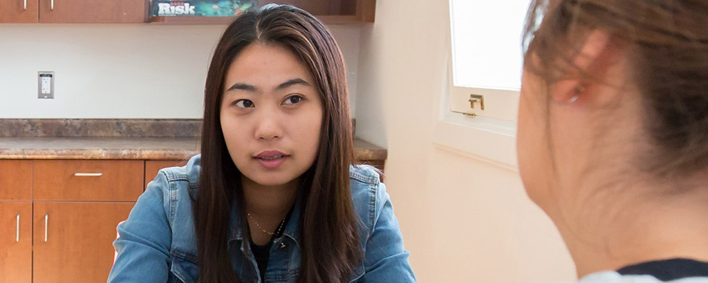 与另一个人坐在桌边的女人