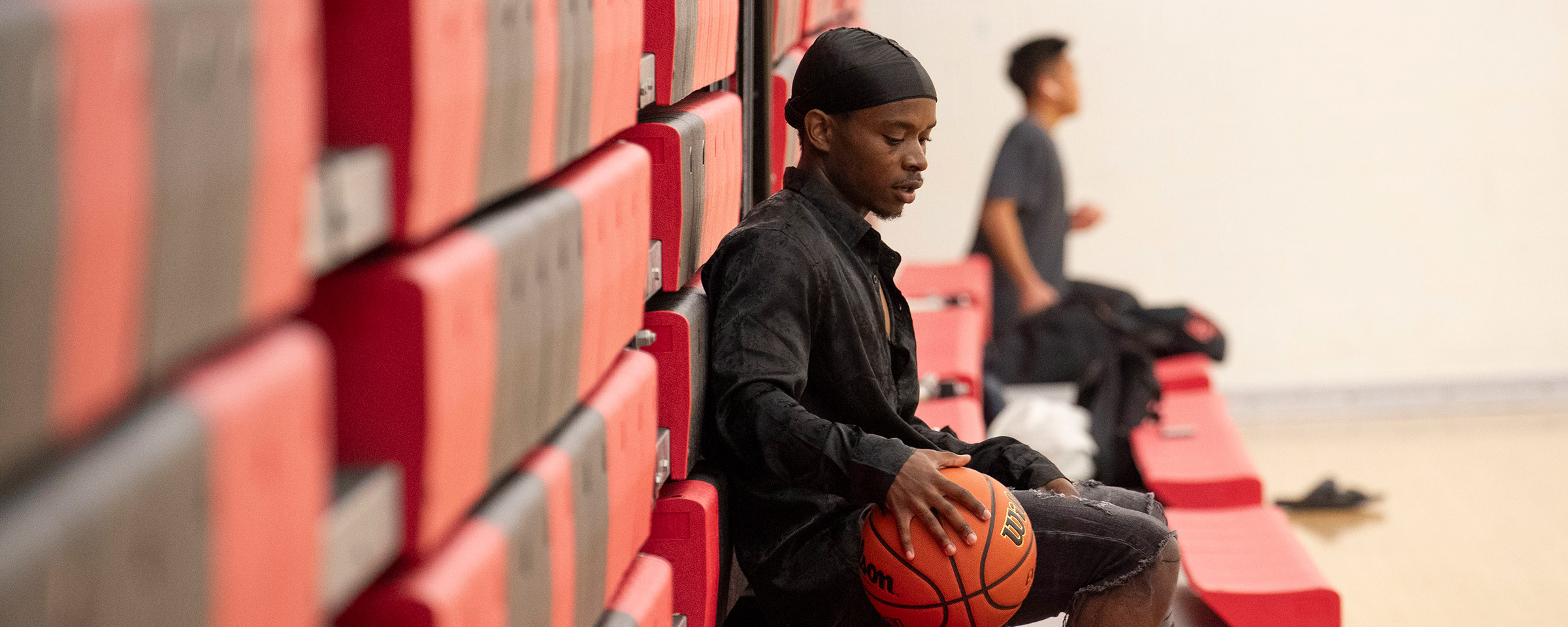 坐在长凳上打篮球的男人