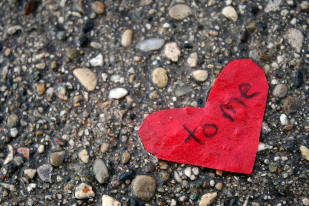 路上有一张红色的心形纸，上面写着“给我”。