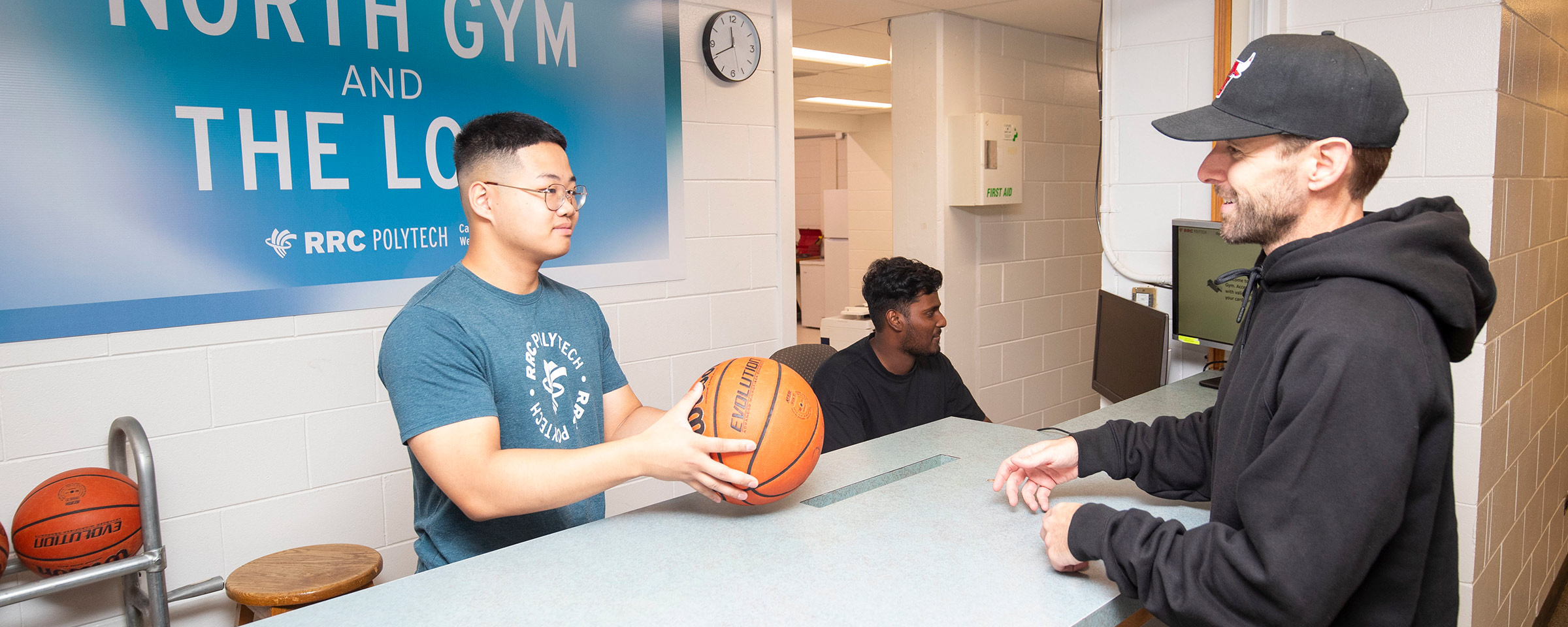 一名男子在柜台前拿着篮球与另一个人交谈